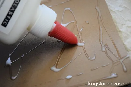 Glue being put on a brown piece of card stock.