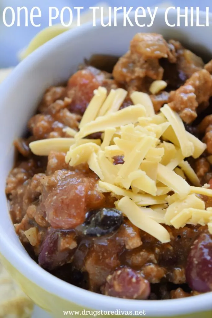 Chili in a yellow bowl with yellow cheese on top and the words "One Pot Turkey Chili" digitally written on top.