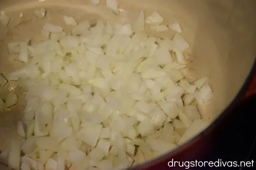 Diced onions in the bottom of a Dutch oven.