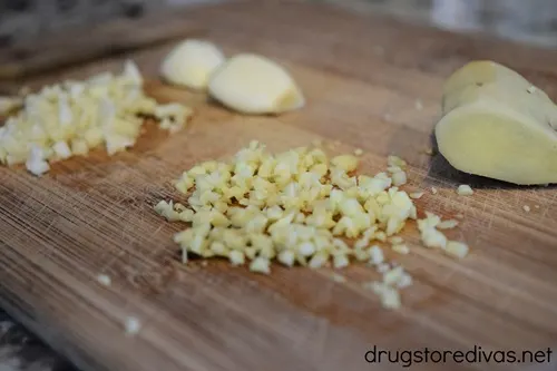 Chopped garlic and ginger on a cutting board.