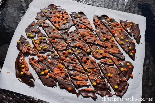 Pieces of Halloween chocolate bark on top of a piece of parchment paper.