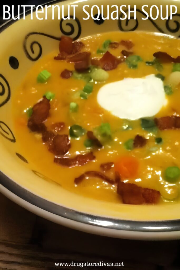 Soup, topped with bacon pieces, green onion, and a dollop of sour cream, in a yellow bowl with the words "Butternut Squash Soup" digitally written on top.