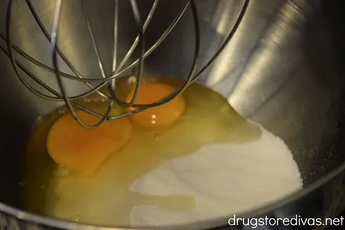 Sugar and eggs in a stand mixer bowl.