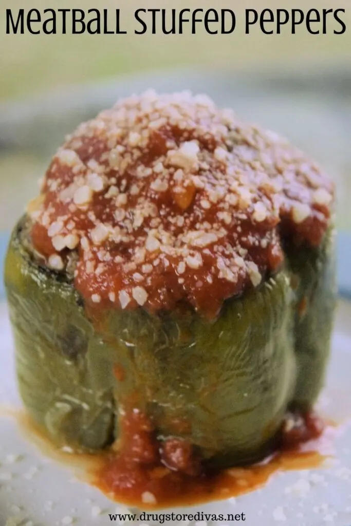 Sauce and cheese on top of a cooked green pepper with the words "Meatball Stuffed Peppers" digitally written on top.