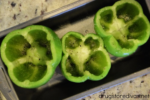 Three cut green peppers in a bread tin.