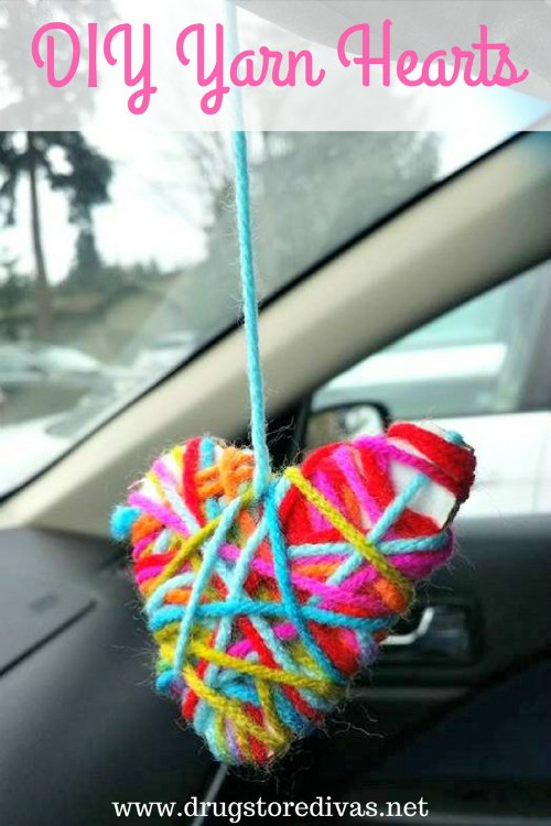 DIY Yarn Hearts hanging from a rear view mirror with the words "DIY Yarn Hearts" digitally written on top.