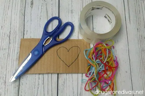 Scissors, cardboard, packing tape, and yarn.