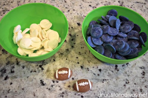 White candy melts and blue candy melts in bowls with two gummy football candies in front of them.