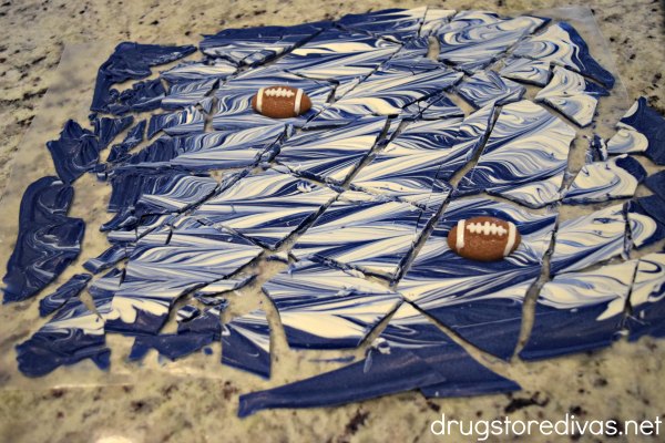 Blue and white candy bark with gummy football candies in it cut into pieces.