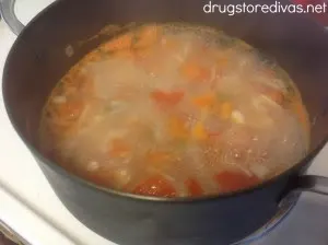 Diced onion, tomato, and jalapeno peppers in a pot of water.