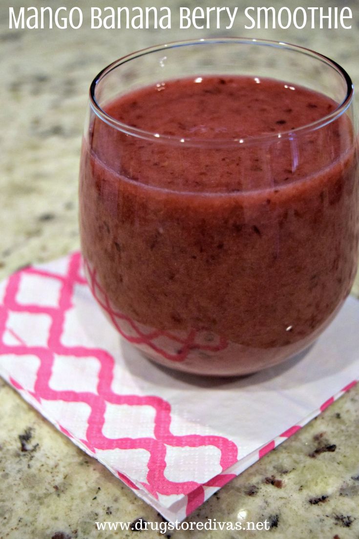 A maroon smoothie in a glass on a pink and white napkin with the words 