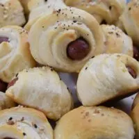 Pigs in a Blanket piled on a plate.