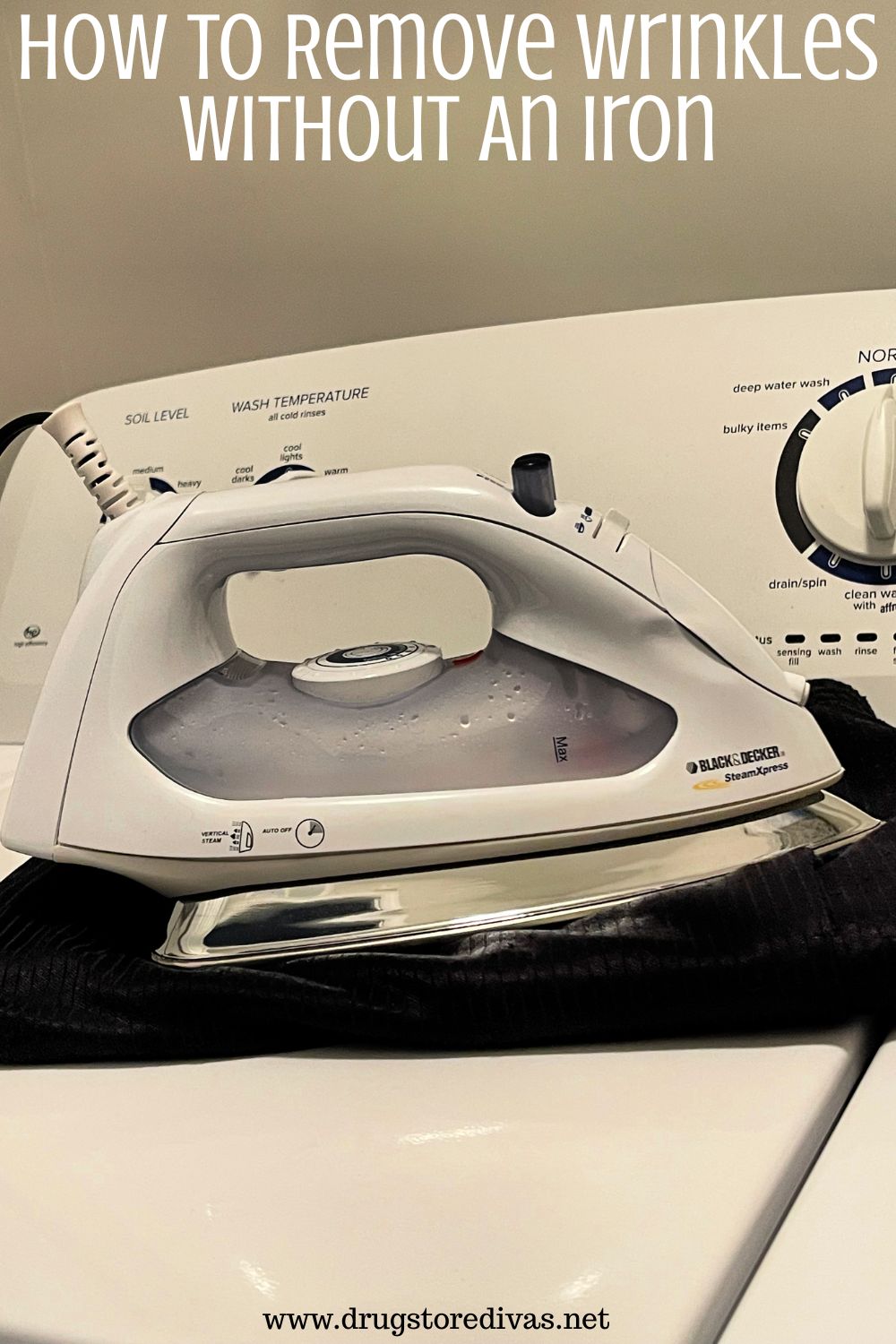 An iron on top of a black shirt on a washing machine with the words 