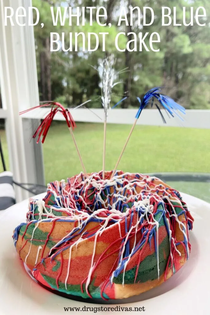 A tricolored bundt cake on a white plate with metallic skewers out the top and the words "Red, White, And Blue Bundt Cake" digitally written on top.