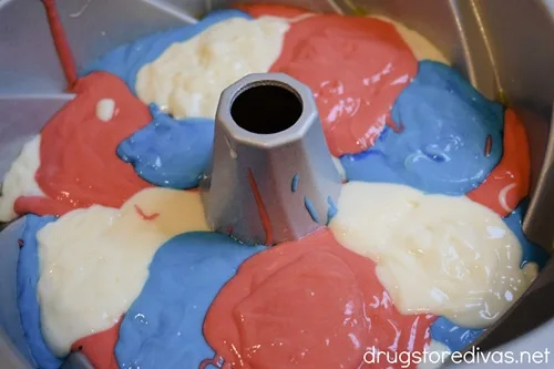 Red, blue, and white cake batter covering the bottom of a Bundt pan.