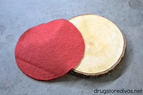 A wooden coaster and a piece of red felt.