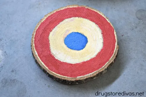 A coaster painted with a red ring and a blue circle in the center.