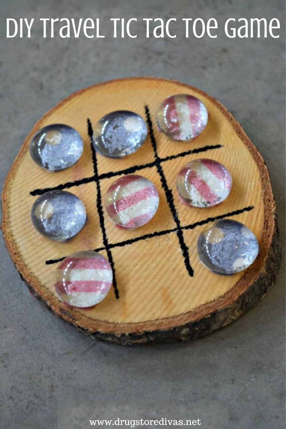 A wooden coaster with a tic tac toe board and pieces on it with the words 