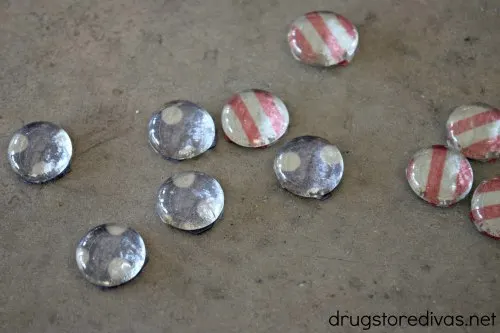 Five blue and white flat marbles and five red and white striped flat marbles.