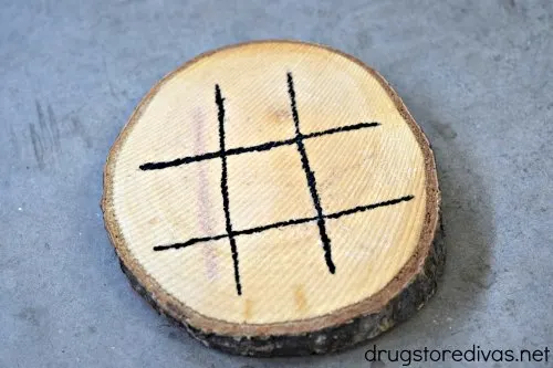 A hashtag painted onto the front of a round wooden coaster.