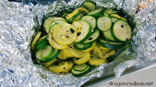 Sliced zucchini and yellow squash in a piece of foil.