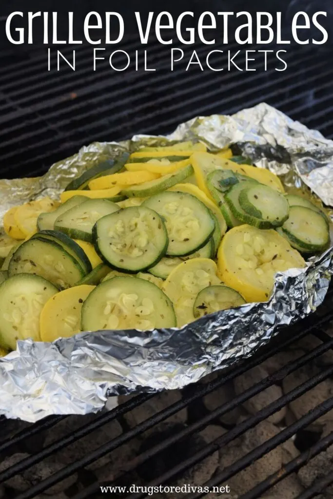 Zucchini and squash in foil on the grill with the words "Grilled Vegetables In Foil Packets" digitally written on top.