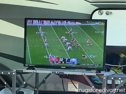 A football game on a small TV outside.
