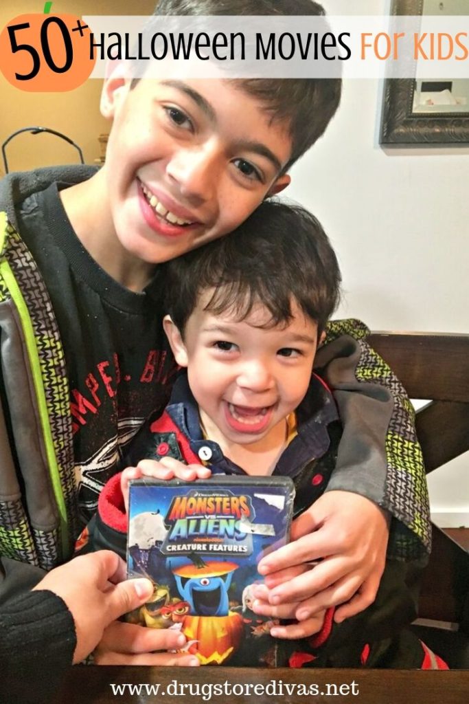 Two kids holding a Halloween DVD with the words "50+ Halloween Movies For Kids" digitally written above them.