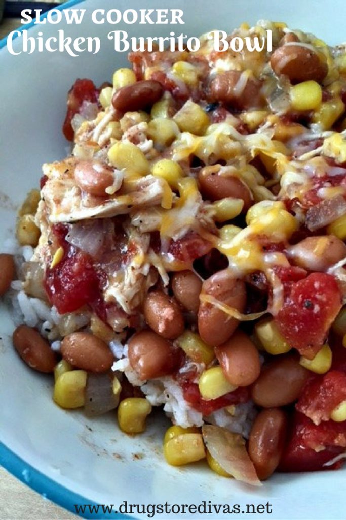 Rice, corn, pinto beans, tomatoes, chicken and cheese in a bowl with the words "Slow Cooker Chicken Burrito Bowl" digitally written on top.