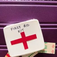 A travel first aid kit on a suitcase with the words 