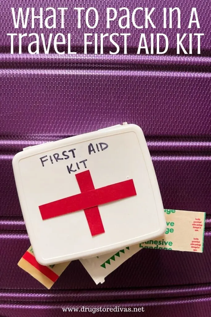 A travel first aid kit on a suitcase with the words "What To Pack In A Travel First Aid Kit" digitally written on top.
