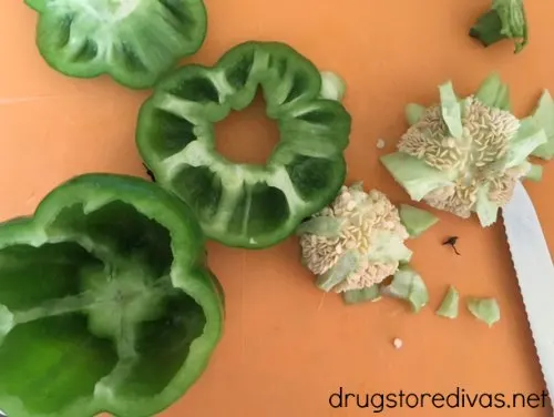 Pepper slices on an orange cutting board.