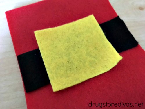 A piece of yellow felt on top of pieces of red and black felt.