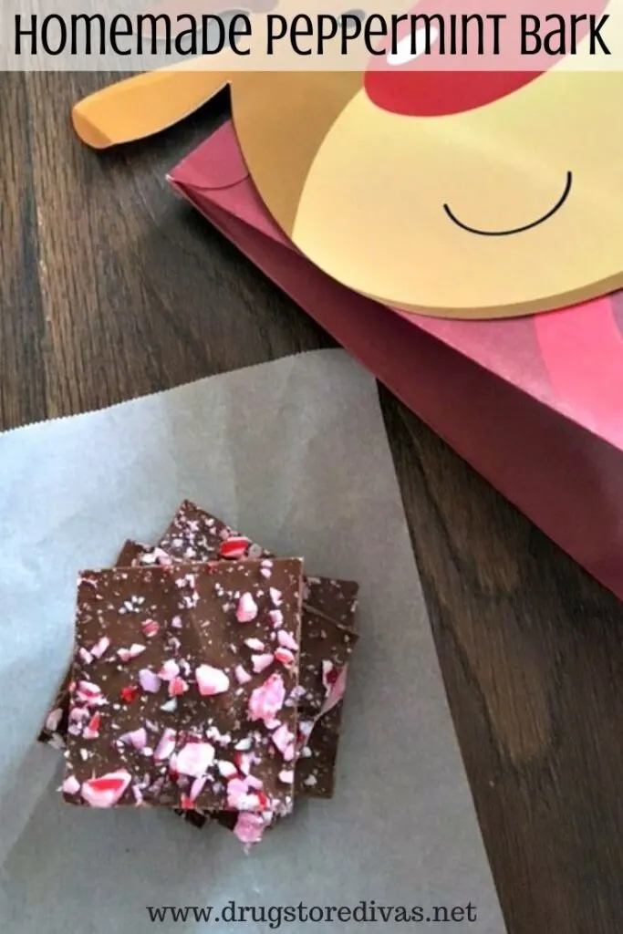 Homemade peppermint bark on a piece of wax paper with a reindeer bag next to it.