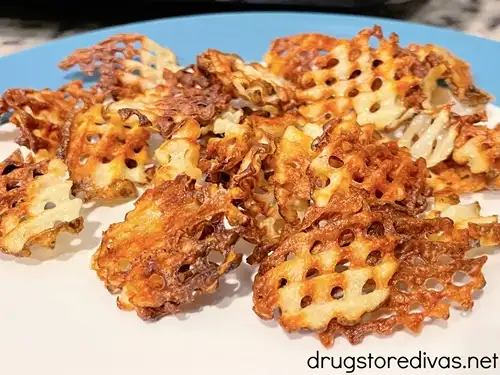 Waffle fries on a blue and white plate.