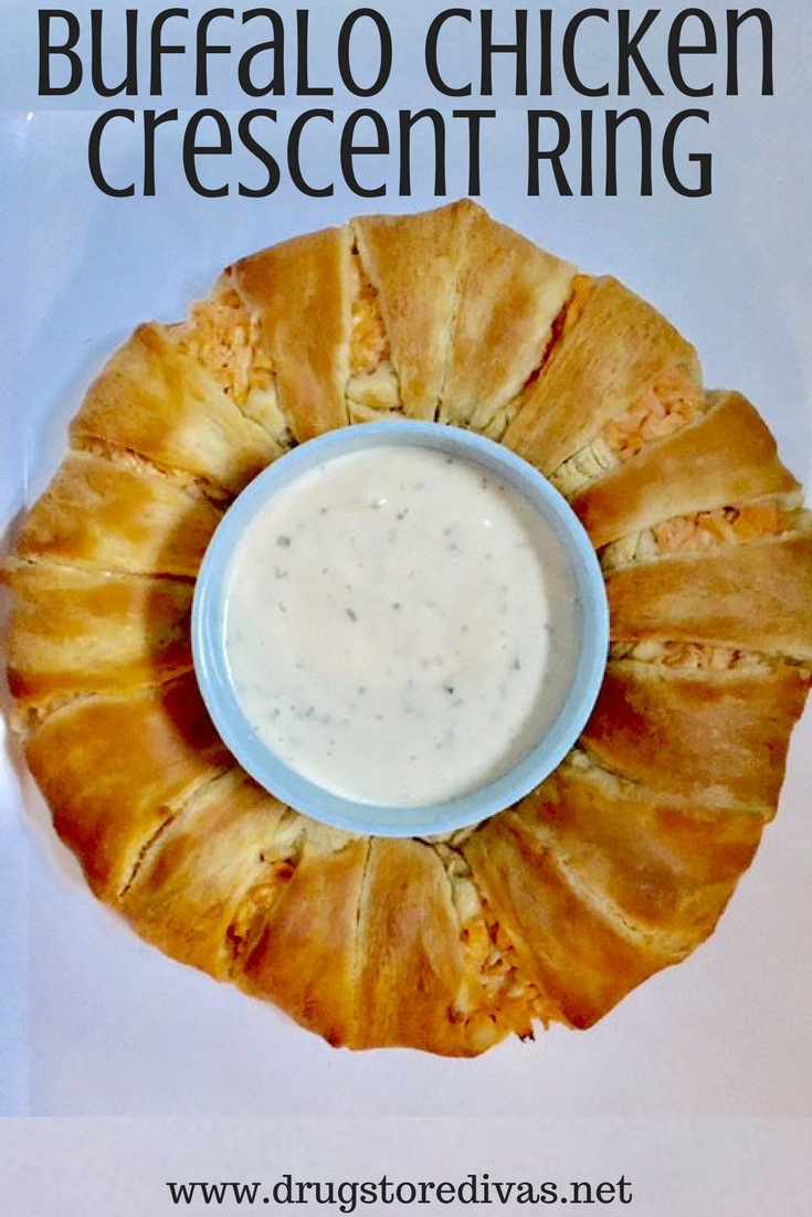 A crescent ring stuffed with Buffalo chicken with dip in the center and the words "Buffalo Chicken Crescent Ring" digitally written on top.