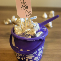 A purple bucket filled with Hershey's Kisses with a tag that says I Dig You sticking out and the words 