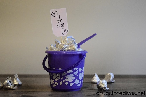 A homemade I Dig You treat bucket on a table with Hershey's Kisses around it..