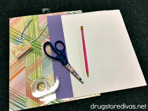 A gift bag, purple card stock, white card stock, a pencil, scissors, and tape.