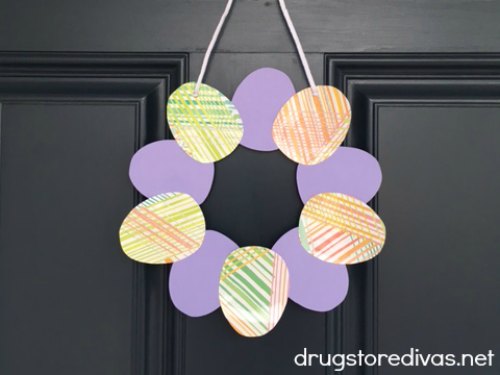 A paper Easter egg wreath hanging on a door.