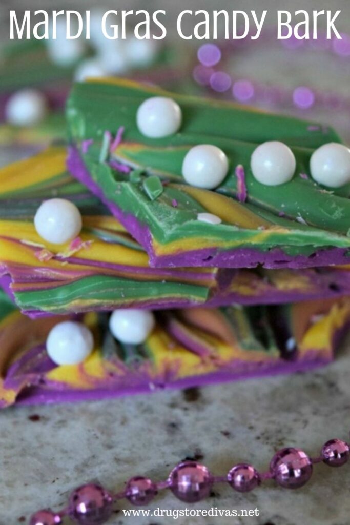 Green, yellow, and purple candy bark, with white sugar pearls, on a pile with beads around it and the words "Mardi Gras Candy Bark" digitally written on top.