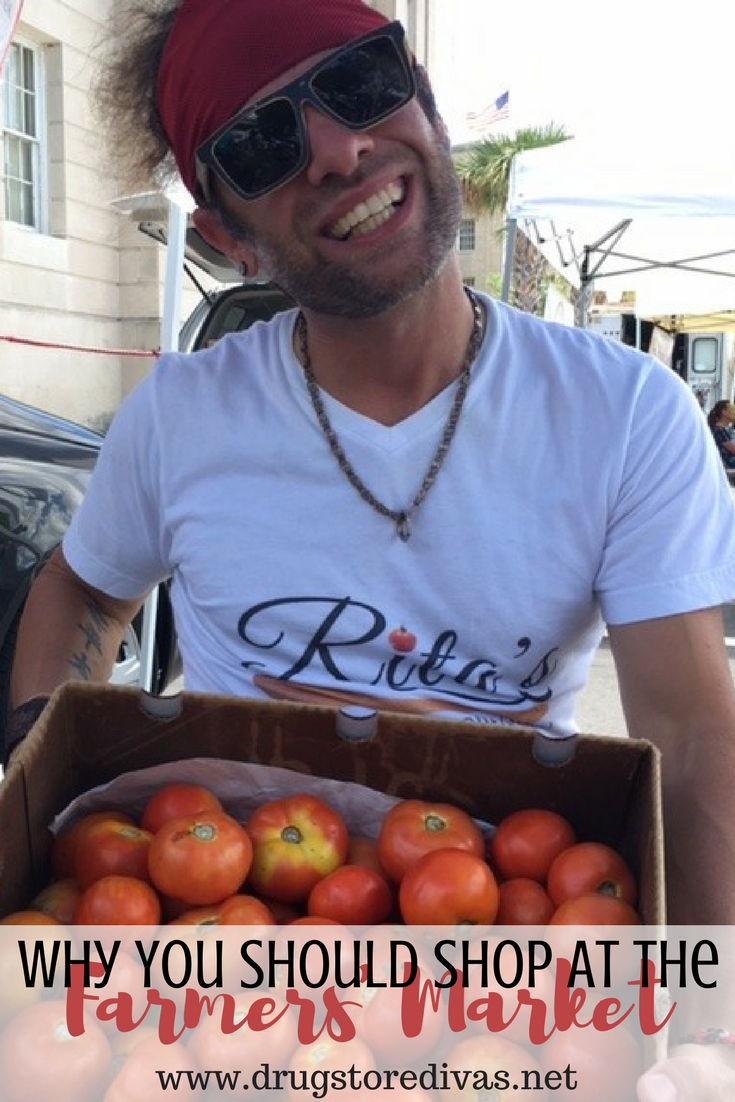 Man holding a box of tomatoes with the words "Why you should shop at the farmers' market" written on it.