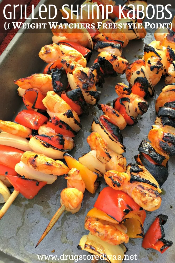 Kabobs with shrimp, onions, and peppers in a metal pan.