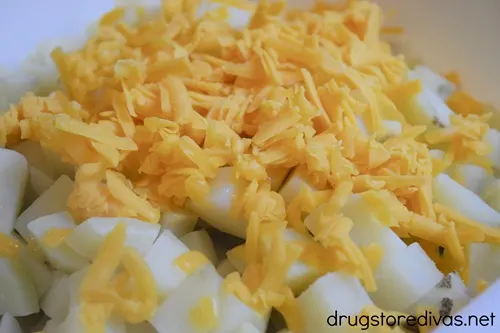 Shredded cheese on top of potato cubes.
