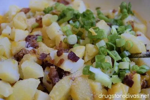 Crispy bacon pieces, green onions, and shredded cheese on top of potato cubes.