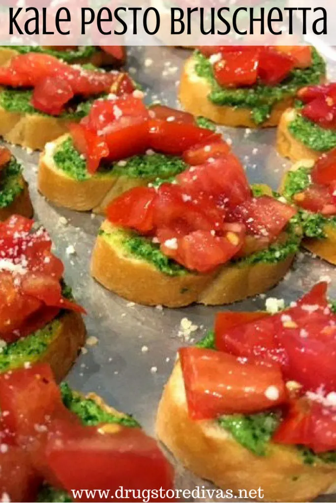 Pieces of bread with pesto, tomato, and parmesan cheese on it with the words "Kale Pesto Bruschetta" digitally written on top.