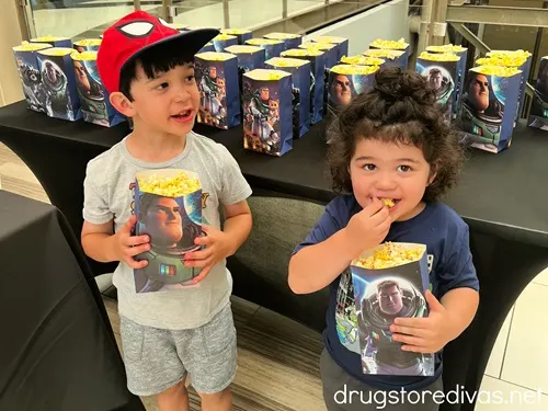 Two boys eating movie theater popcorn.