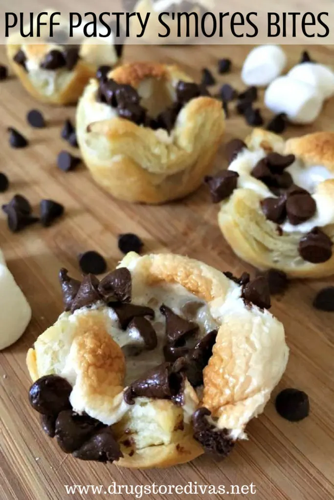 Puff Pastry S'mores Bites on a cutting board surrounded by chocolate chips and the words "Puff Pastry S'mores Bites" digitally written on top.