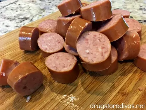 Sausage links cut into slices on a cutting board.