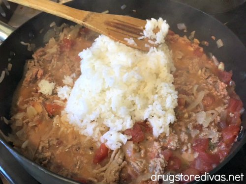 Onions, garlic, diced tomatoes, ground turkey, and rice in a pan.